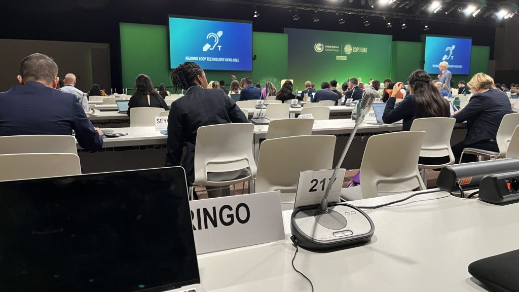 A photo of tables and screens from the COP28 in Dubai