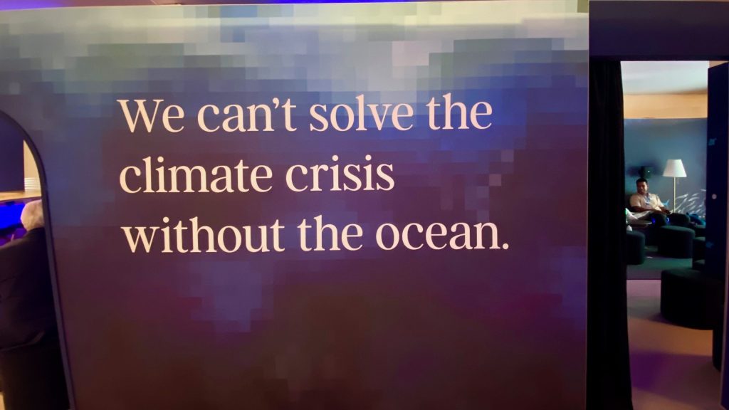A photo of a wall with the text "We can't solve the climate crisis without the ocean."