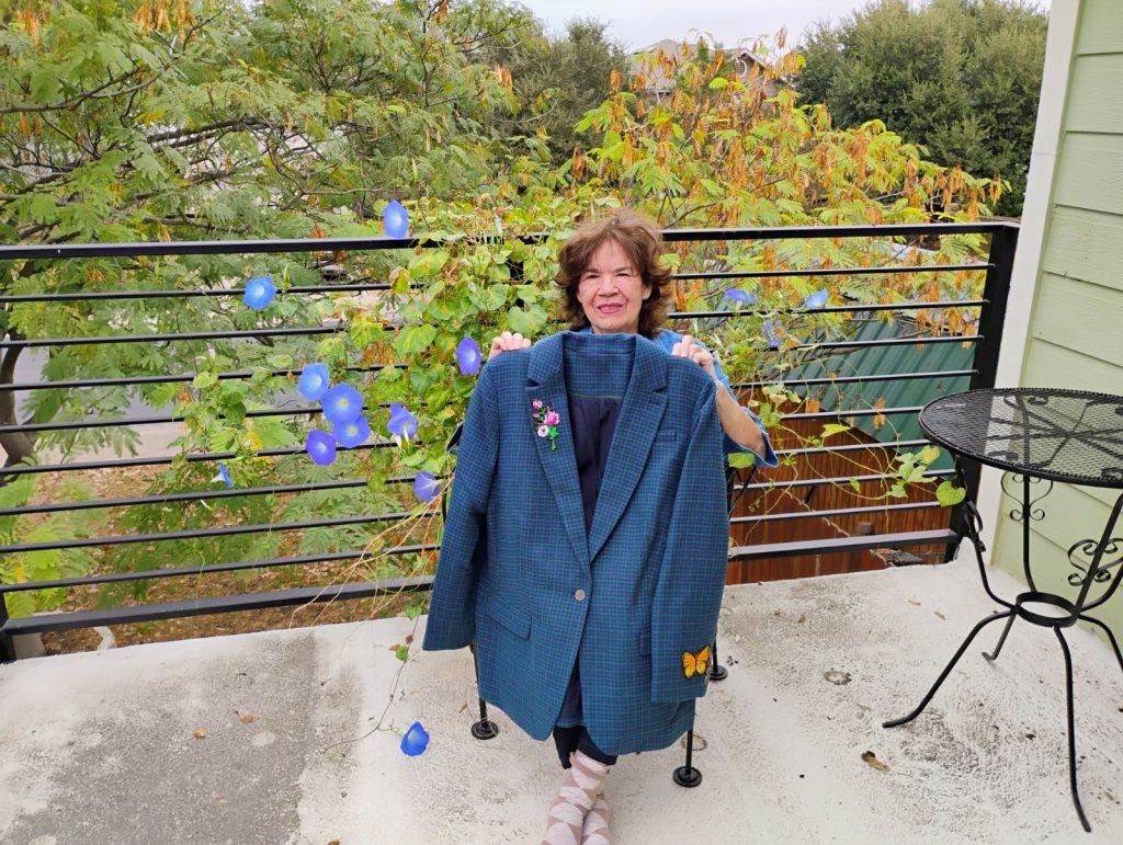 A photo of Emma Quijada Vega Fain holding up a blazer she made