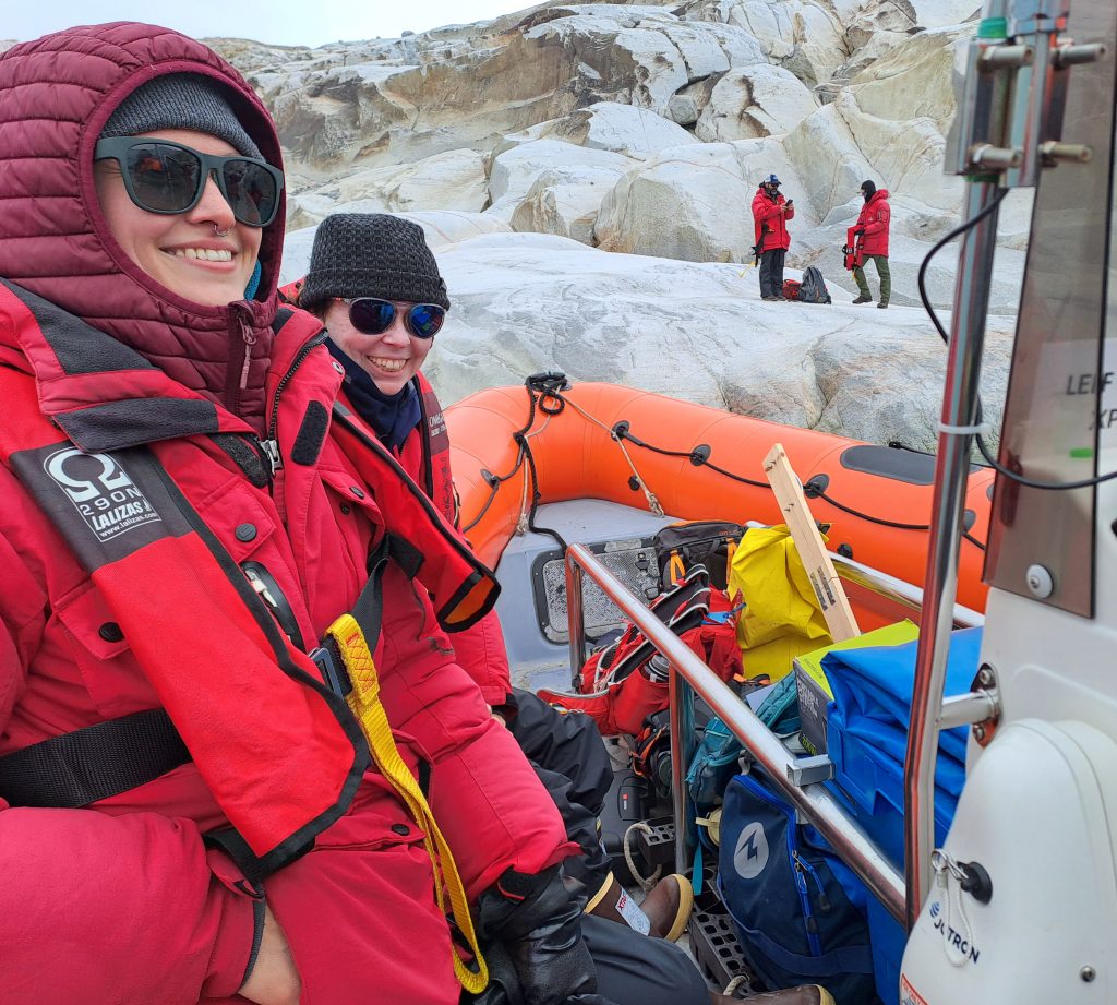 Team members on Zodiac boat with field equipment for fjord sampling.