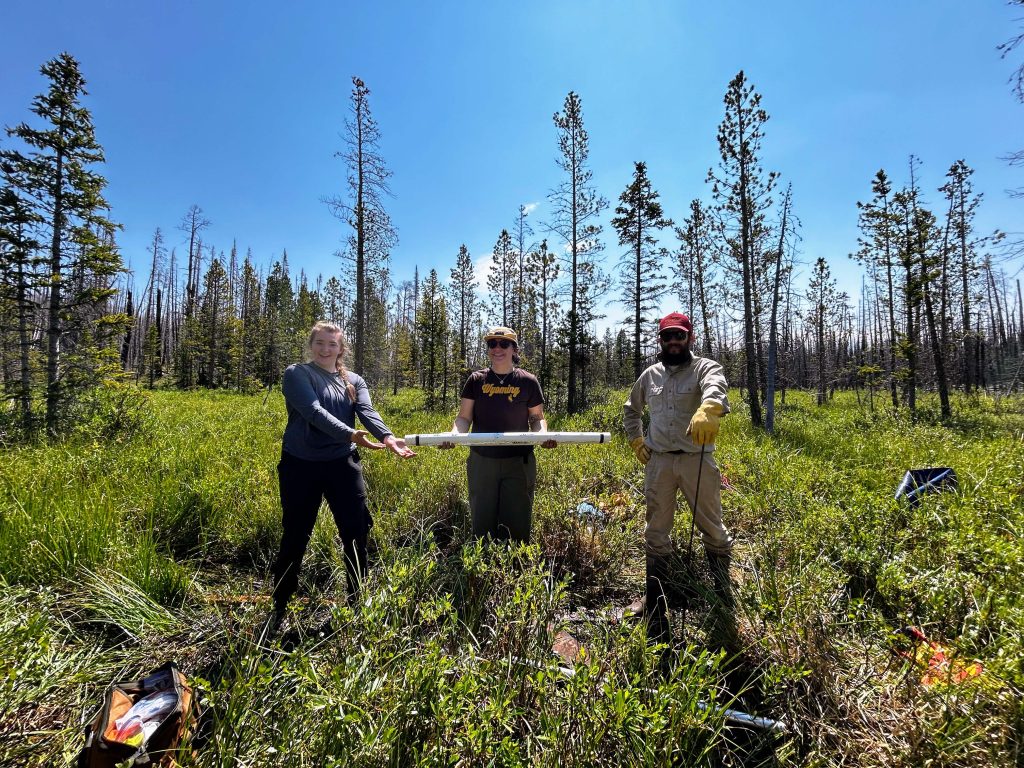 Photo of field team members holding sediment core.