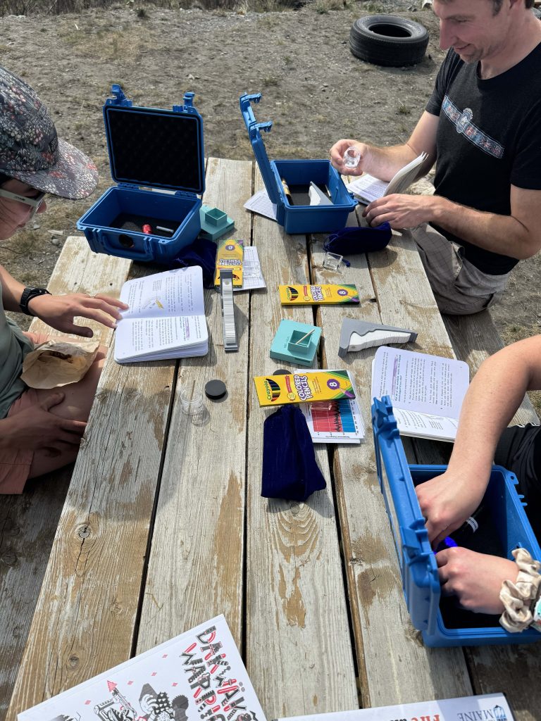 UMaine field team seated on picnic table testing the Ice Core Activity package.