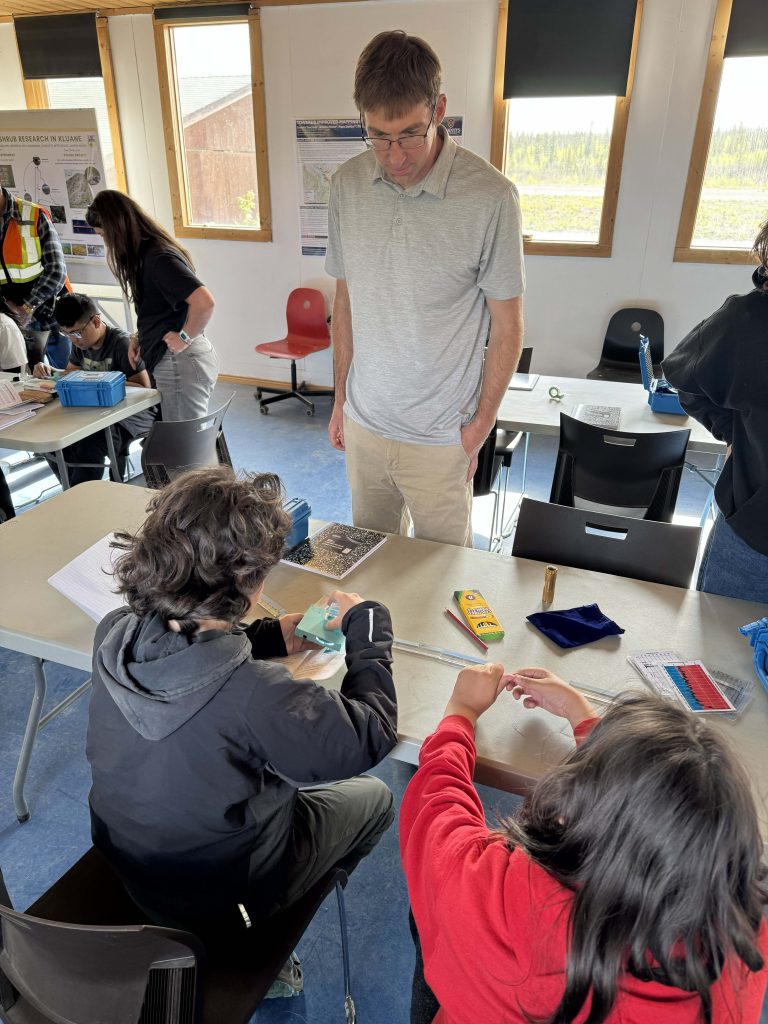 Sixth grade students and researchers discussing contents of kits.